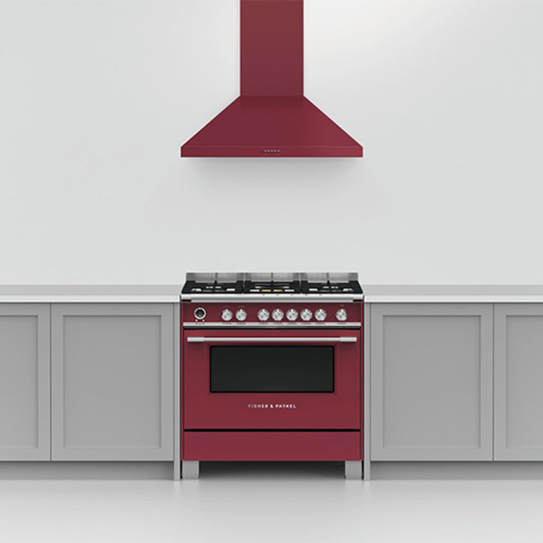 Red dual fuel cooker with matching rangehood in a modern kitchen setting