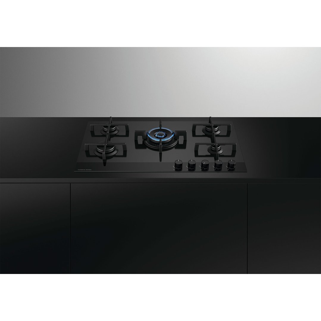 Black gas on glass cooktop with five burners and controls in a modern kitchen