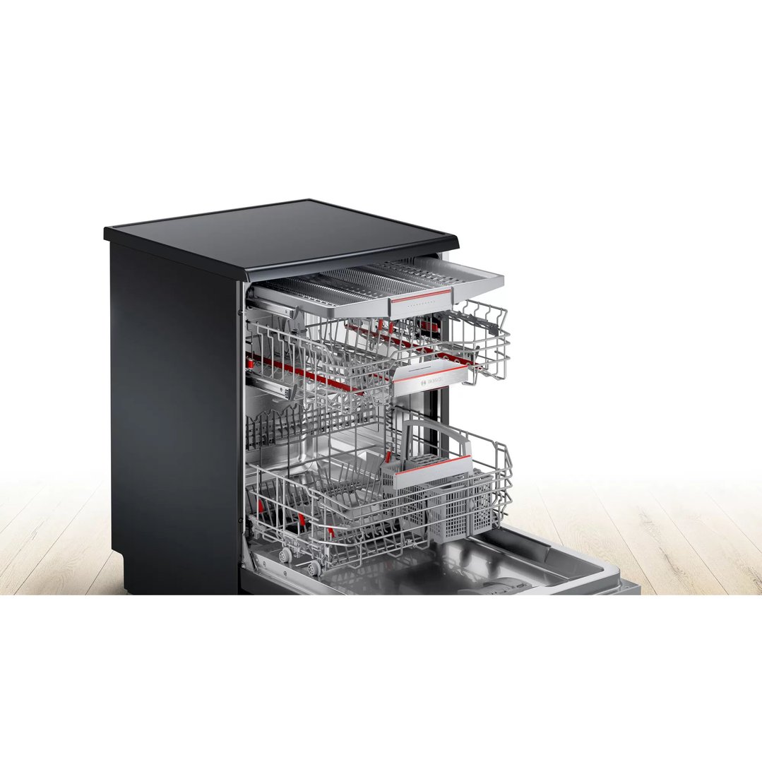 Black freestanding dishwasher with racks pulled out on a wooden floor