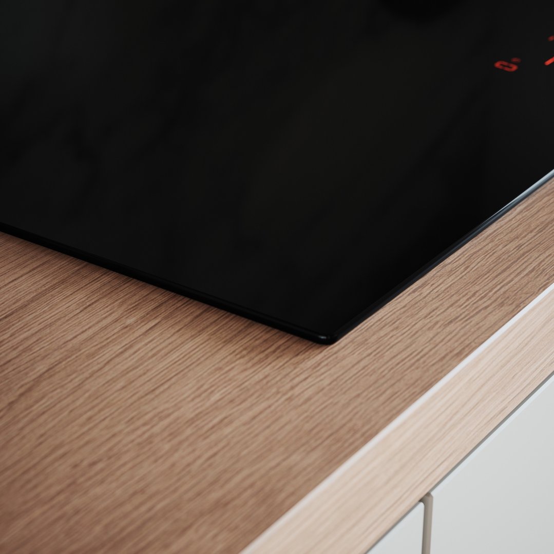 Close up of a black induction cooktop built into a wooden countertop