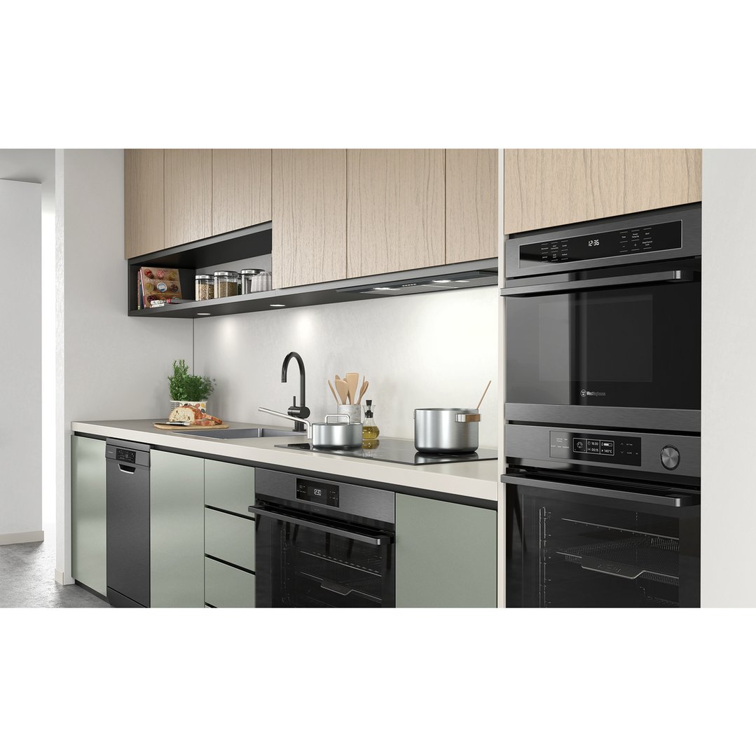 Built-in combination microwave and oven in a modern kitchen with light wood cabinets