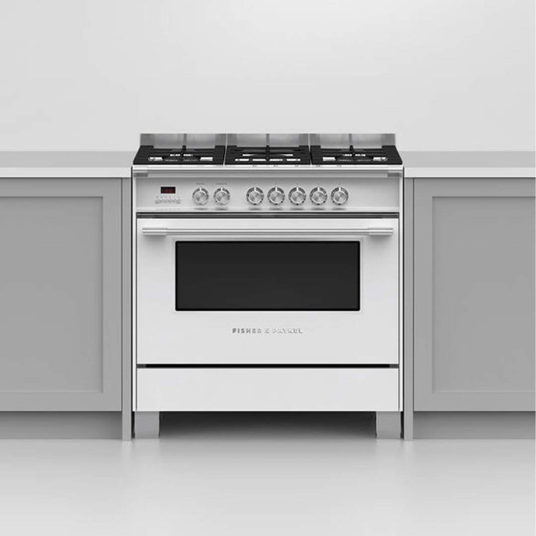 White freestanding oven with gas cooktop installed between grey kitchen cabinets