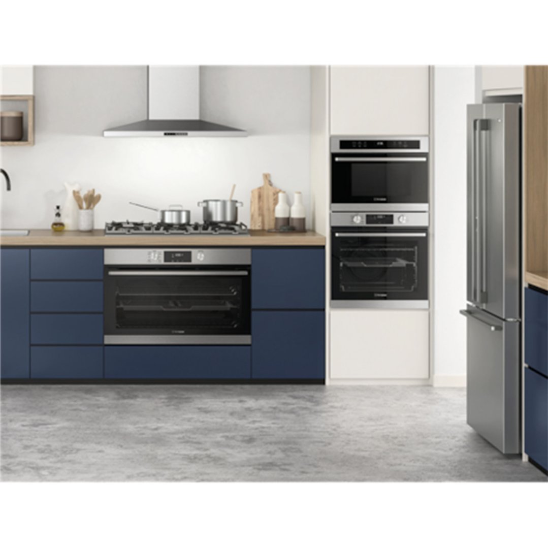 Modern kitchen with built-in ovens, cooktop, rangehood, and refrigerator