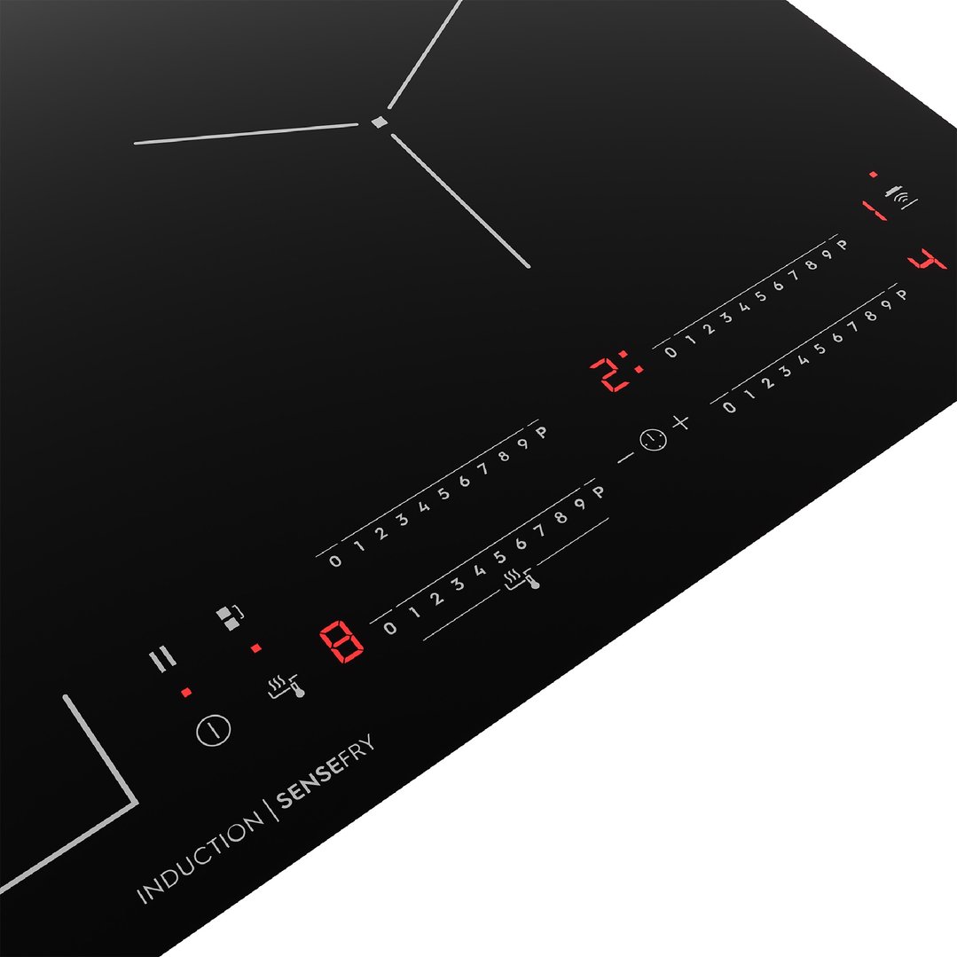 Close-up of an induction cooktop with illuminated controls and cooking zones