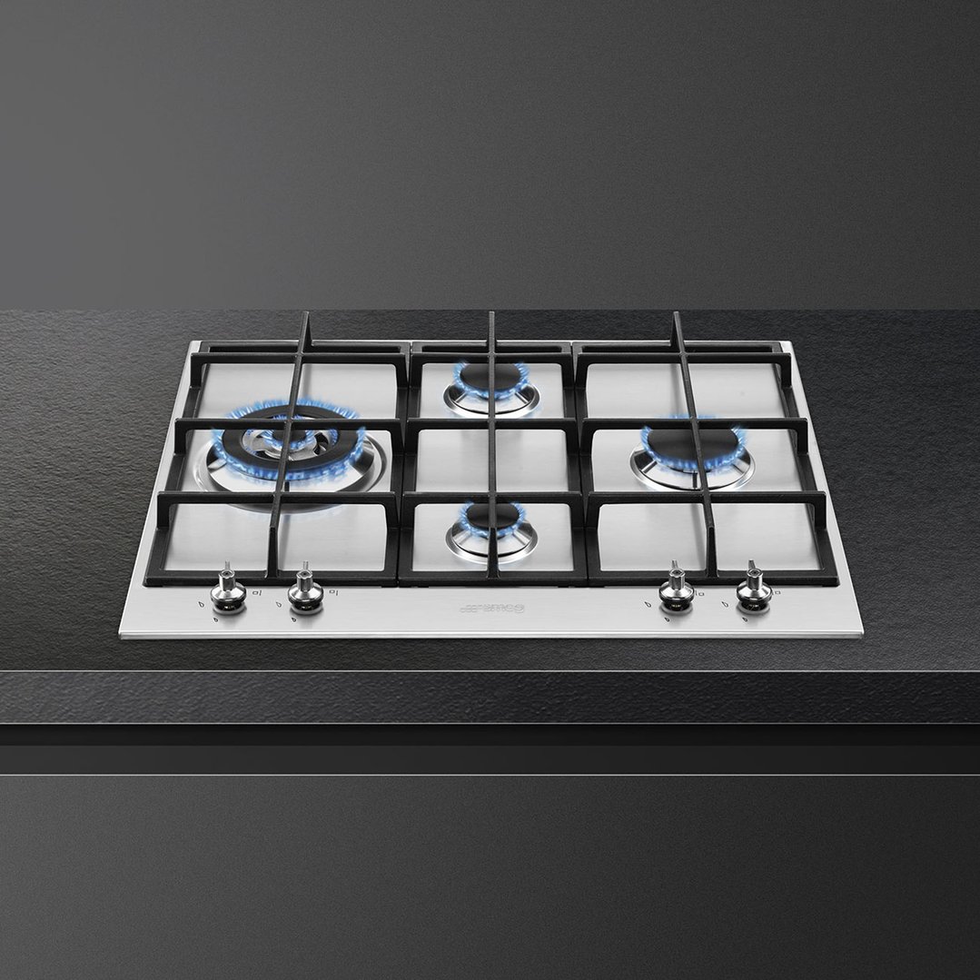 SMEG 60cm Classic Gas Cooktop with four burners lit on a dark countertop