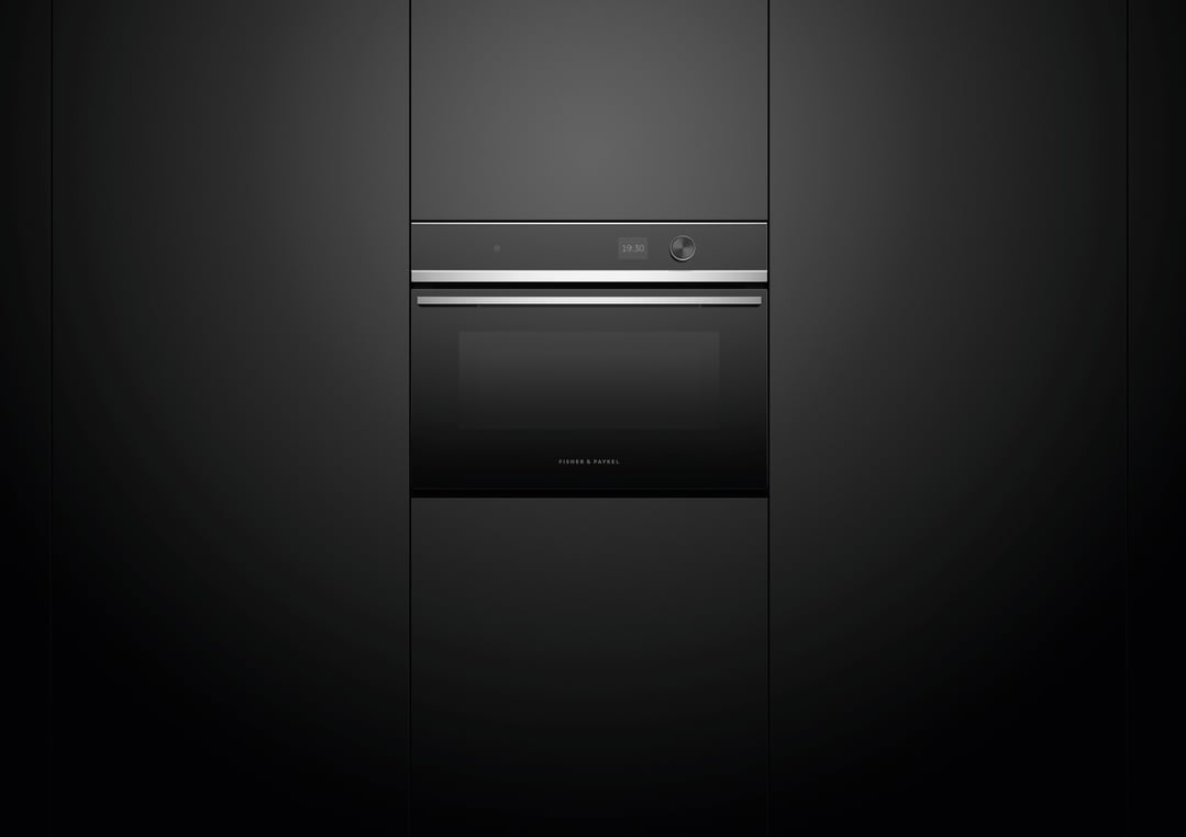 Built-in microwave oven with digital display and control knob in a dark kitchen