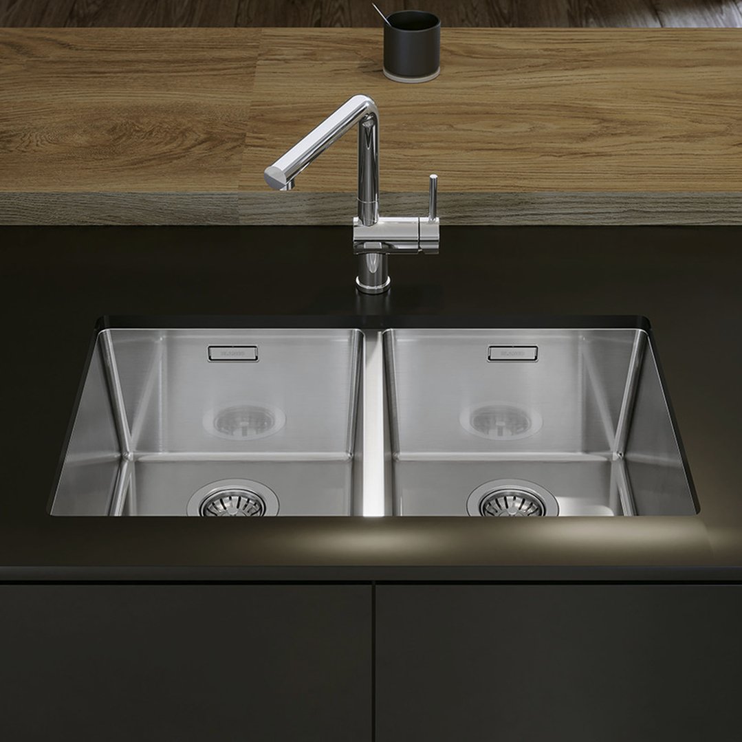 Double bowl sink with a chrome faucet in a modern kitchen setting