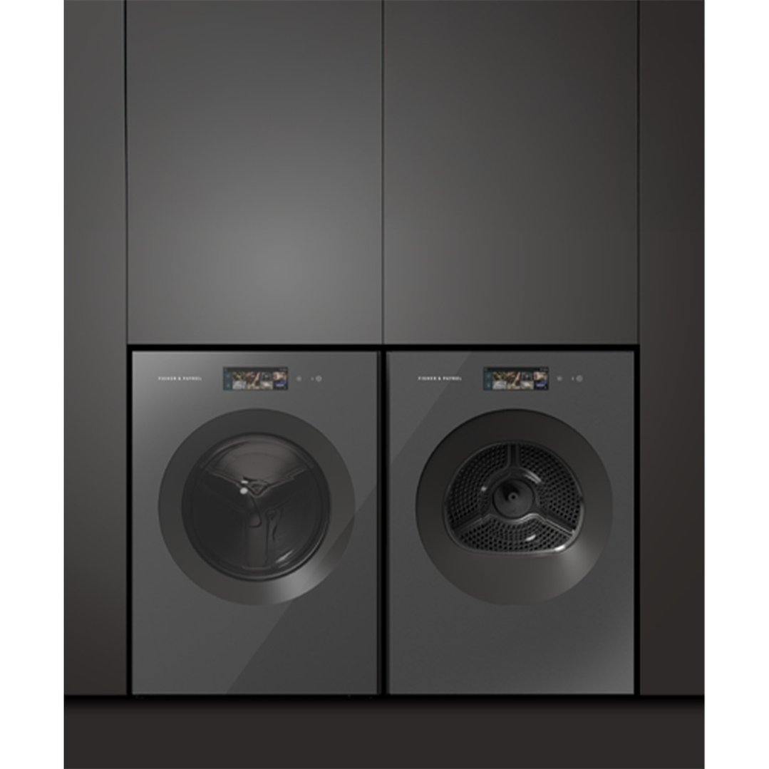 Two dark grey front loader washing machines installed side-by-side in a dark laundry