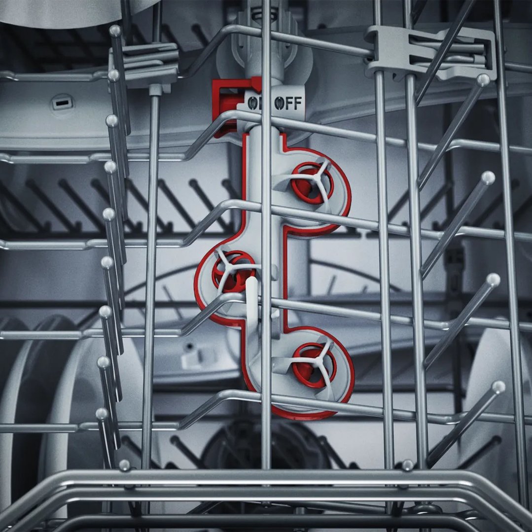 Close-up of the interior of a dishwasher with a red and white spray arm