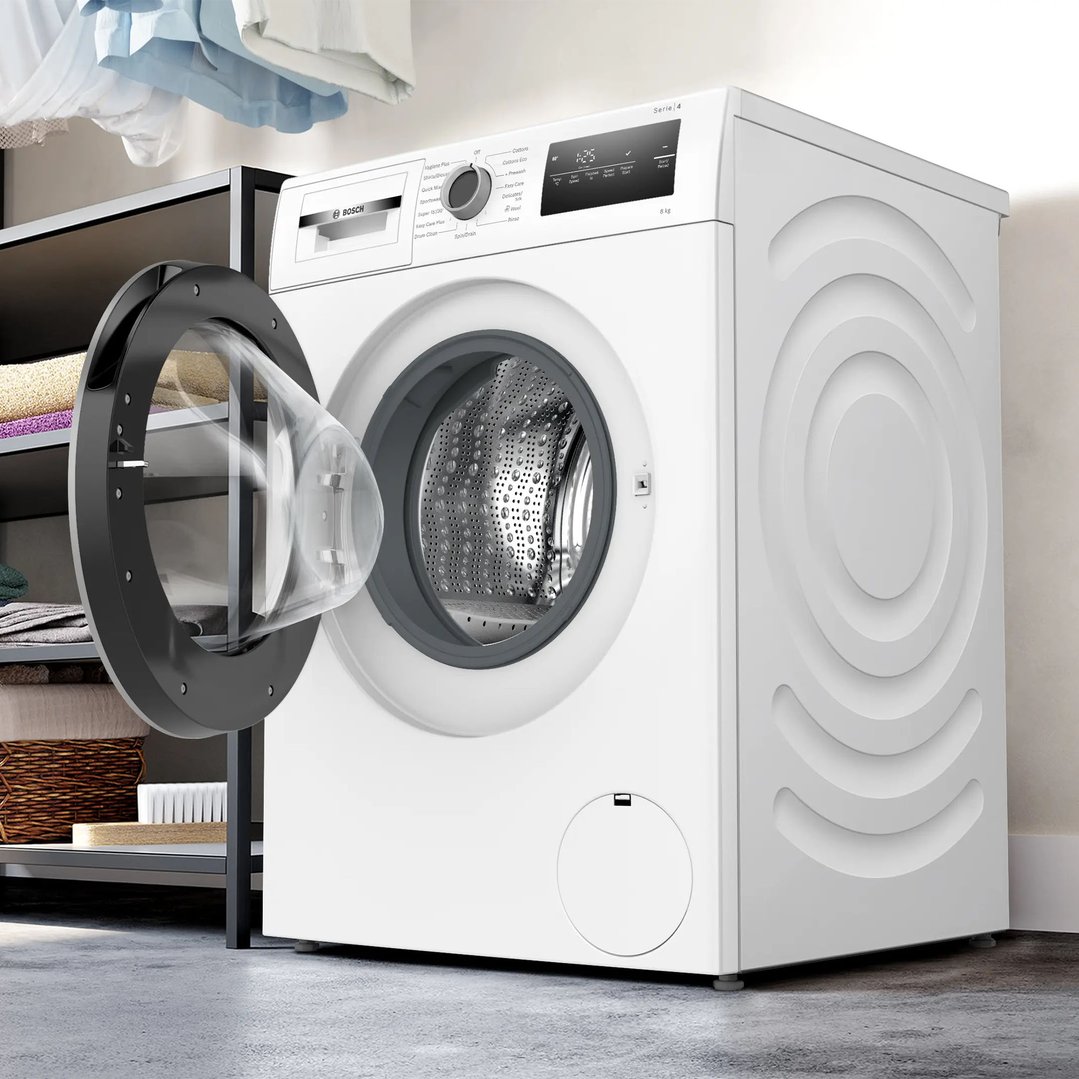 White Bosch washing machine with open door in a laundry room setting