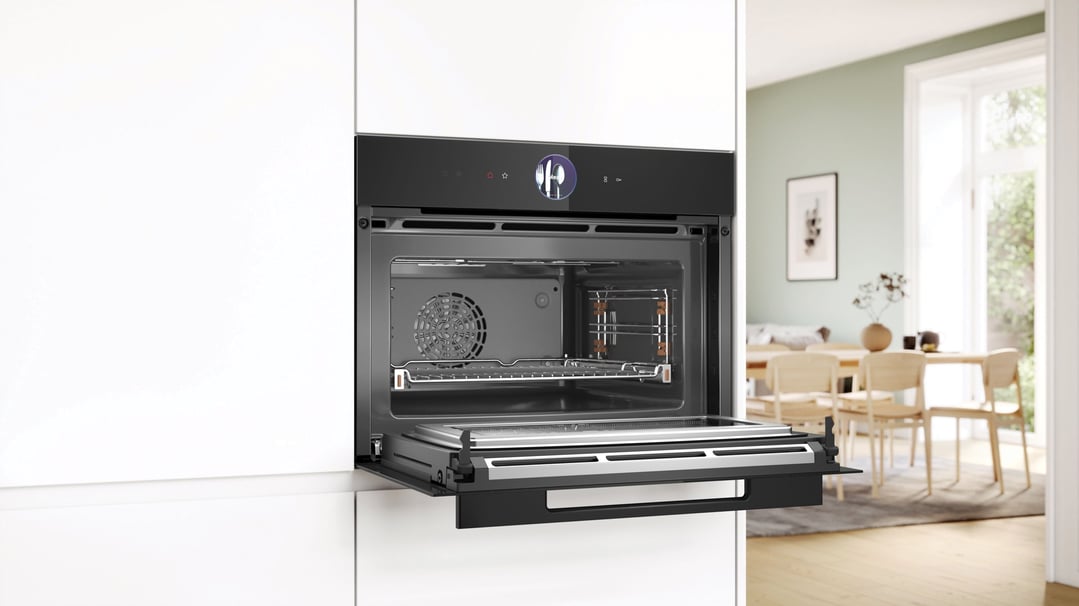 Open built-in combination oven with microwave in a modern kitchen setting