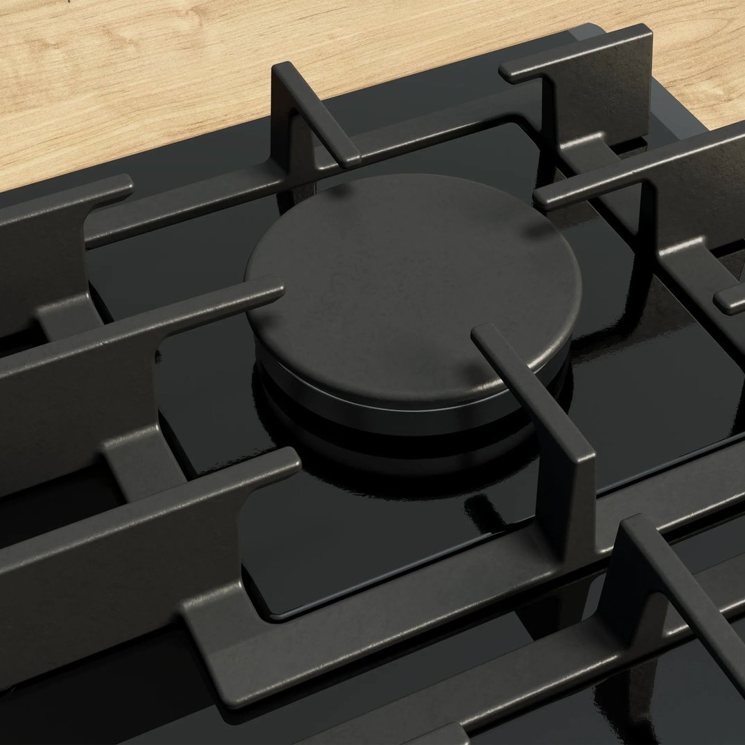 Close-up of a black gas cooktop with grates on a wooden countertop