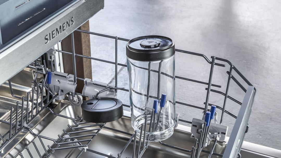 Close-up of a Siemens dishwasher rack with a glass jar and other items