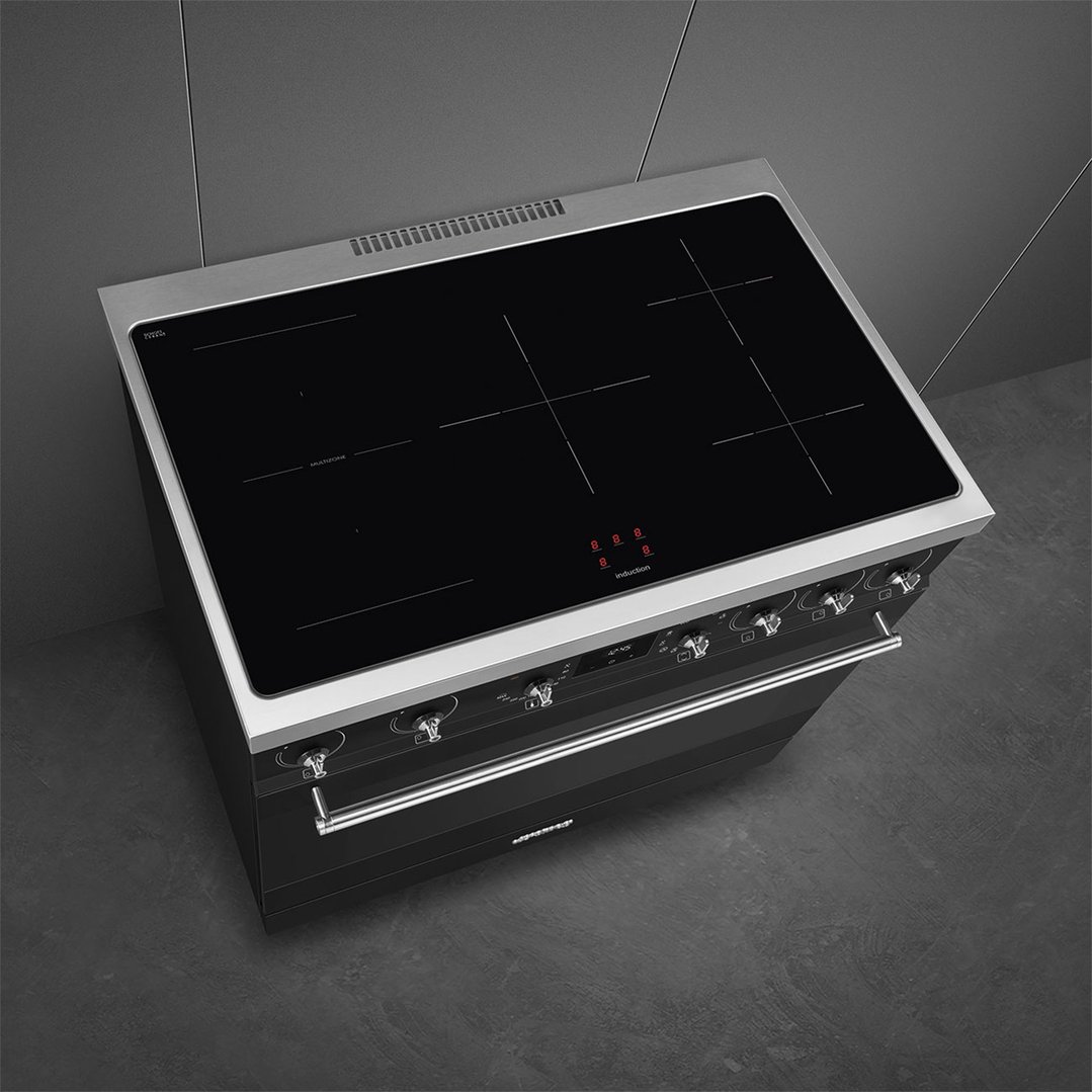 Black freestanding cooker with induction hob in a dark kitchen setting
