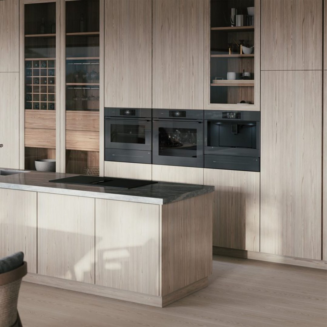 Three built-in ovens and a coffee machine in a modern kitchen with an island