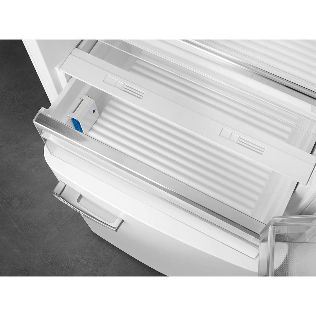 Close up of the interior of a white refrigerator with drawers and shelves