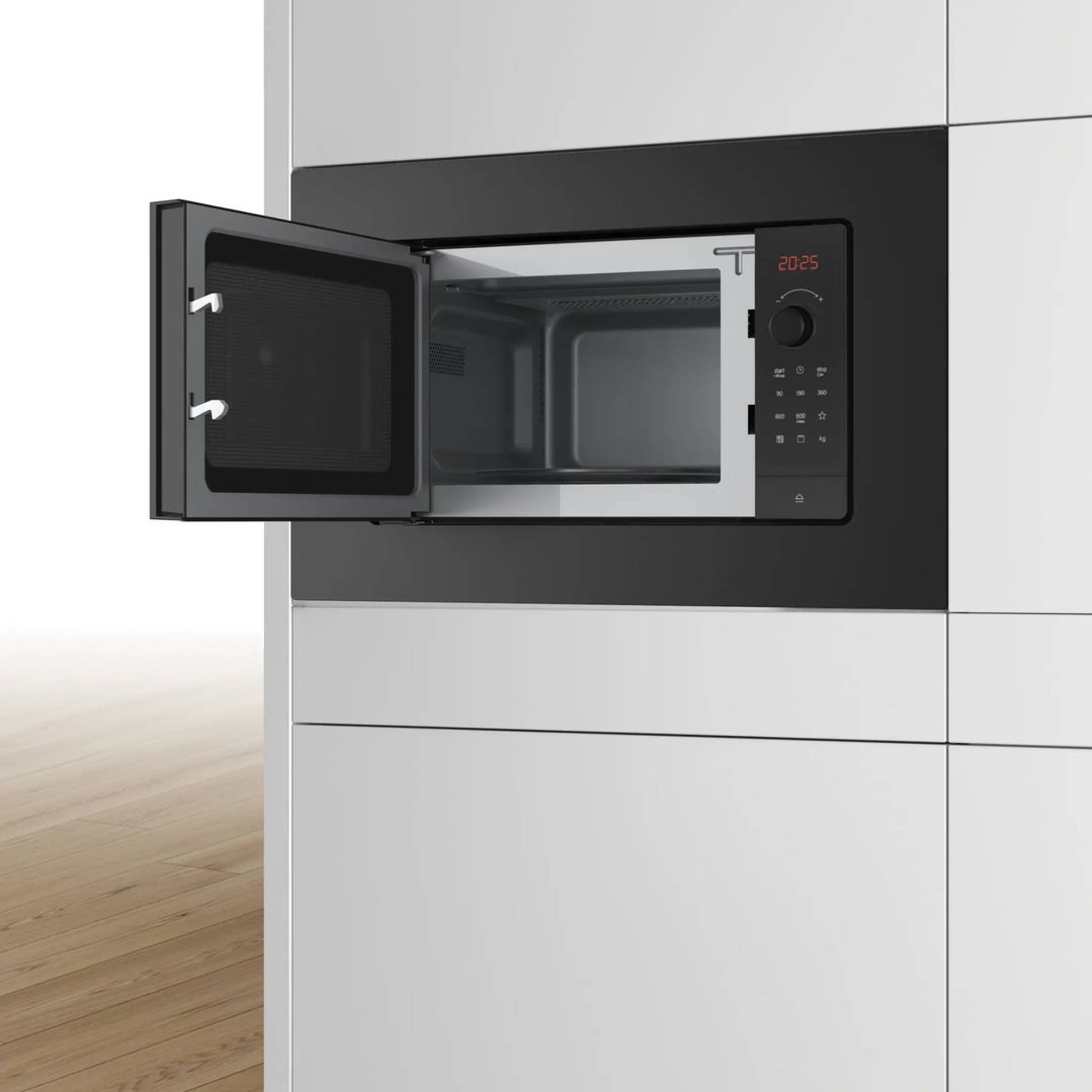 Built-in microwave oven with door open in a modern kitchen setting