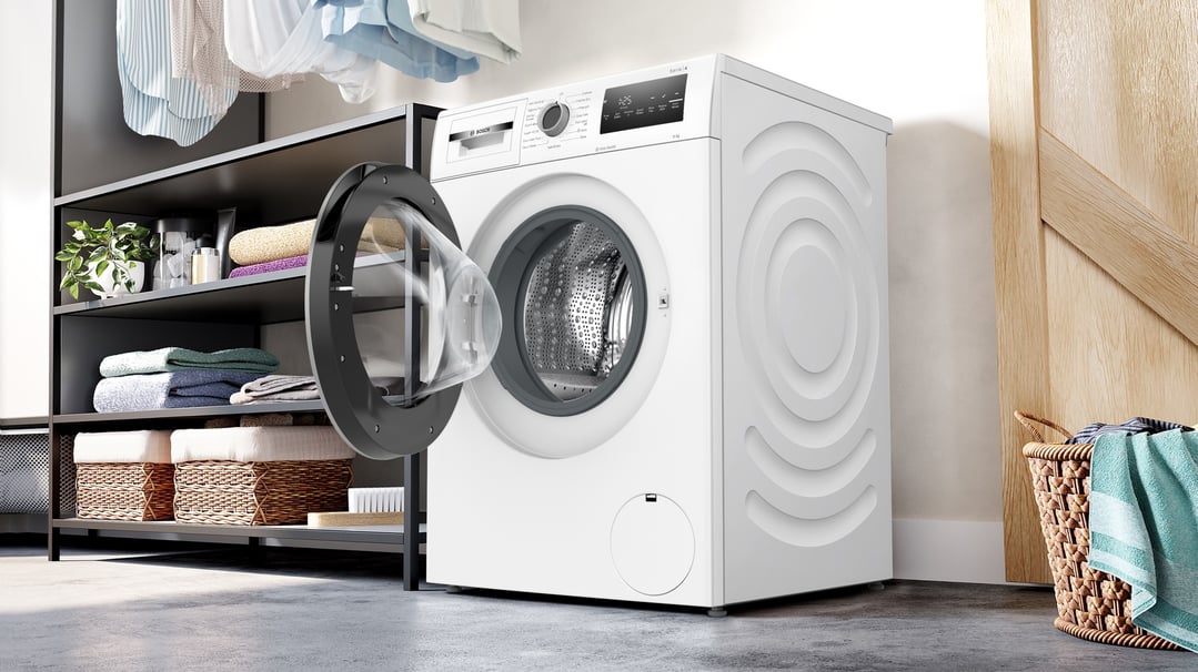 White Bosch front loader washing machine with door open in a laundry room
