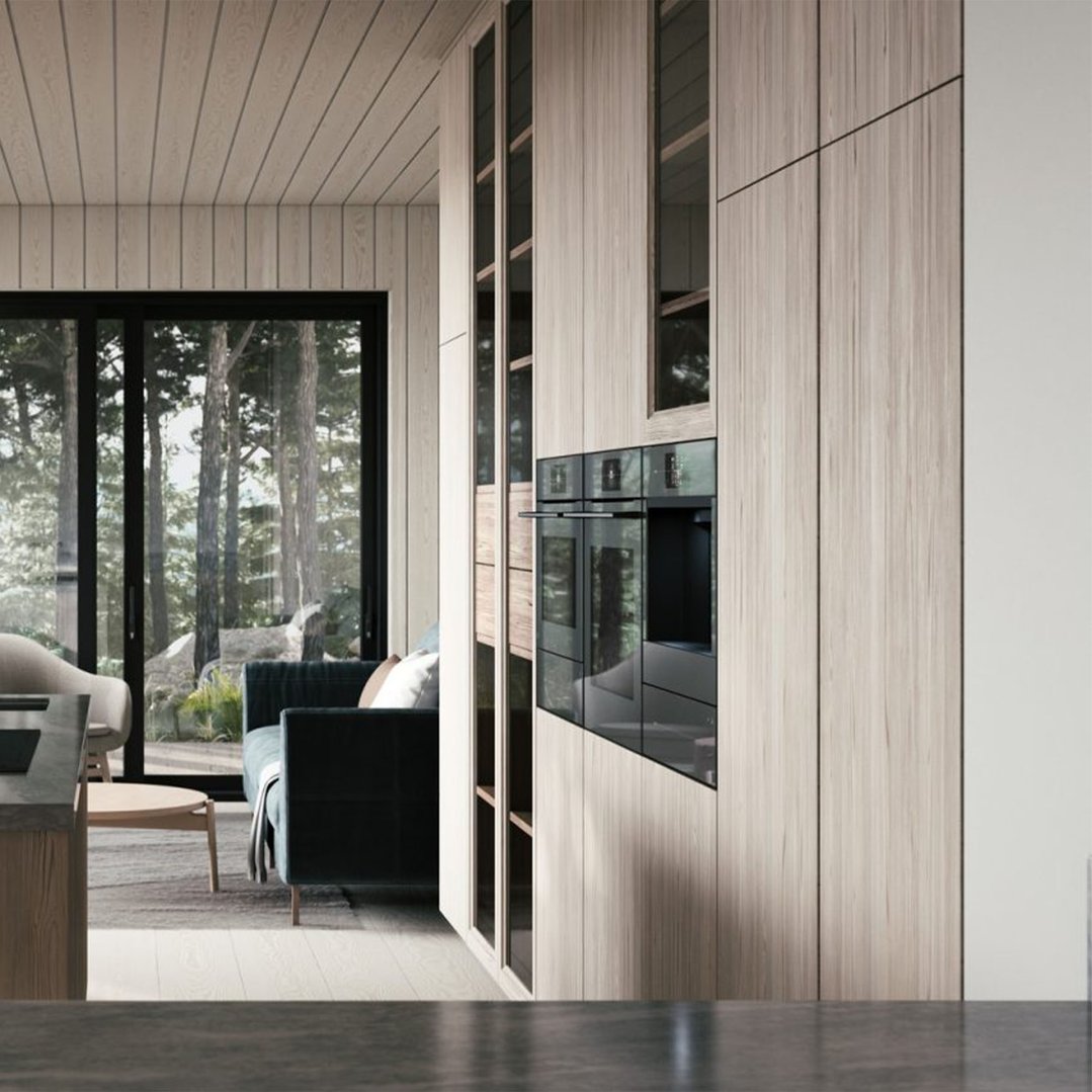 Built-in coffee machine and oven in a modern kitchen with a view of trees