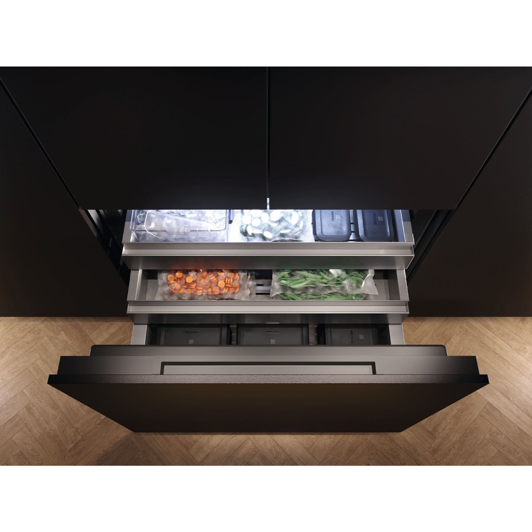 Open integrated French door fridge drawers with vegetables and ice inside