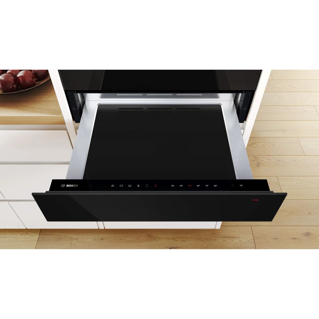 Black Bosch warming drawer partially open in a kitchen setting