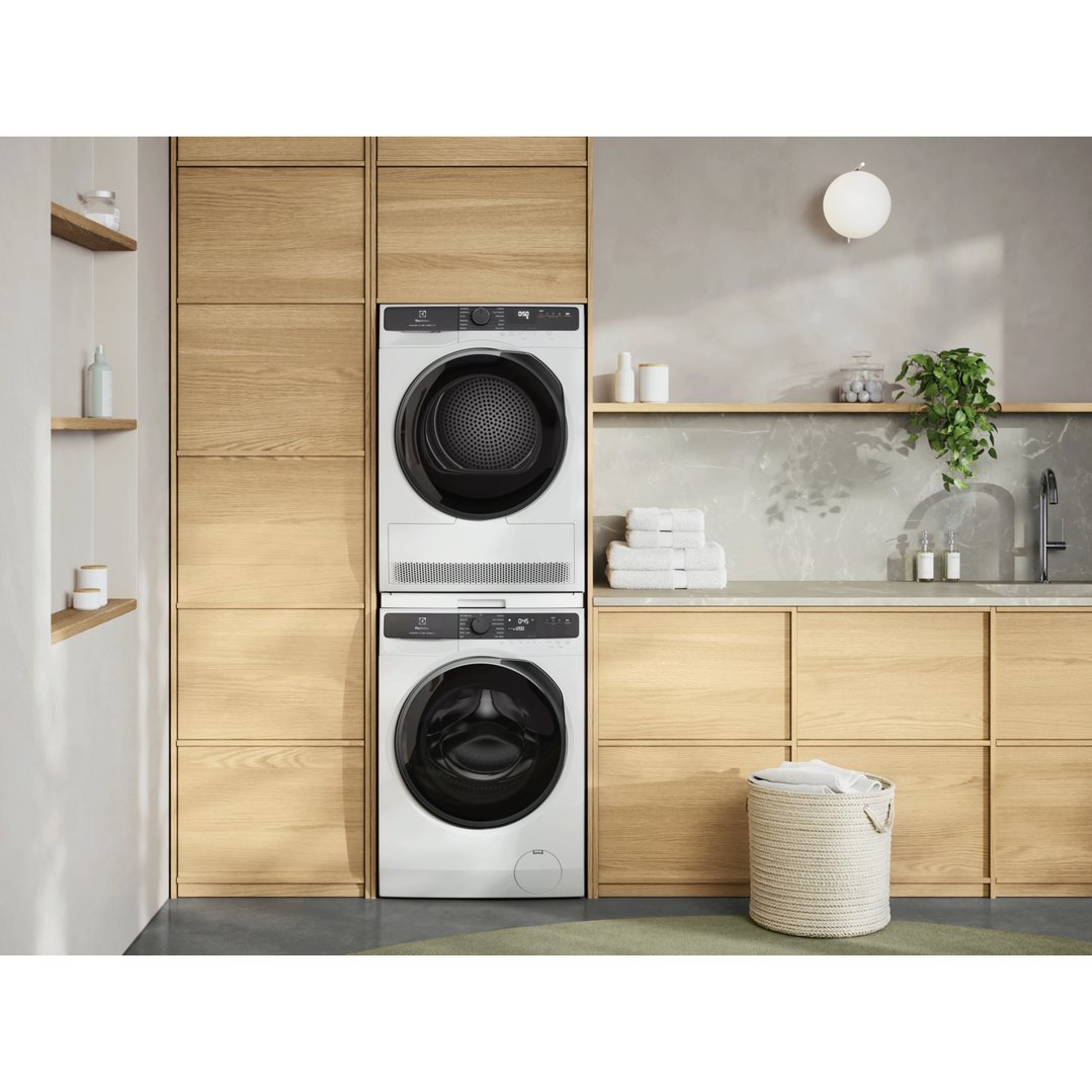 White washing machine and dryer stacked in a modern laundry room