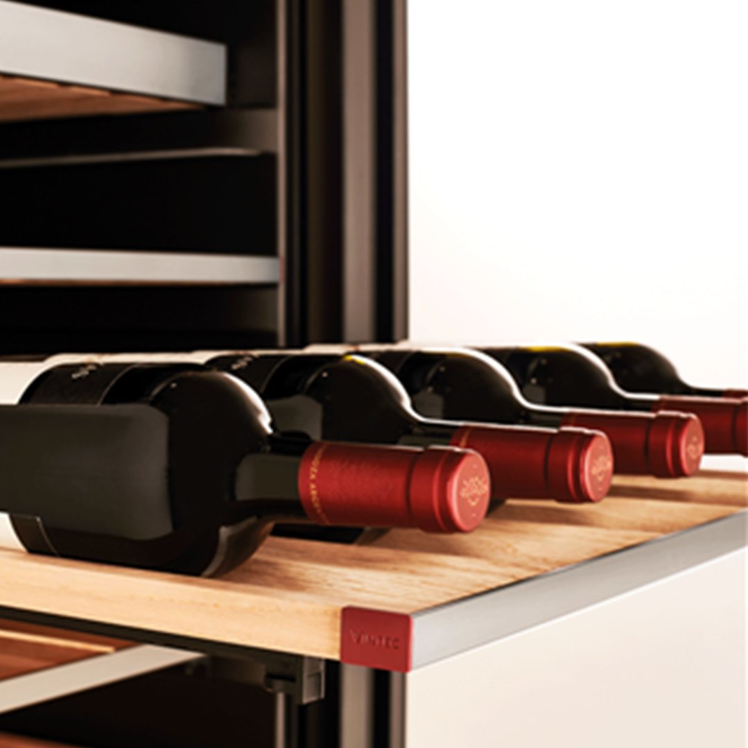 Red wine bottles on a wooden shelf inside a wine cabinet