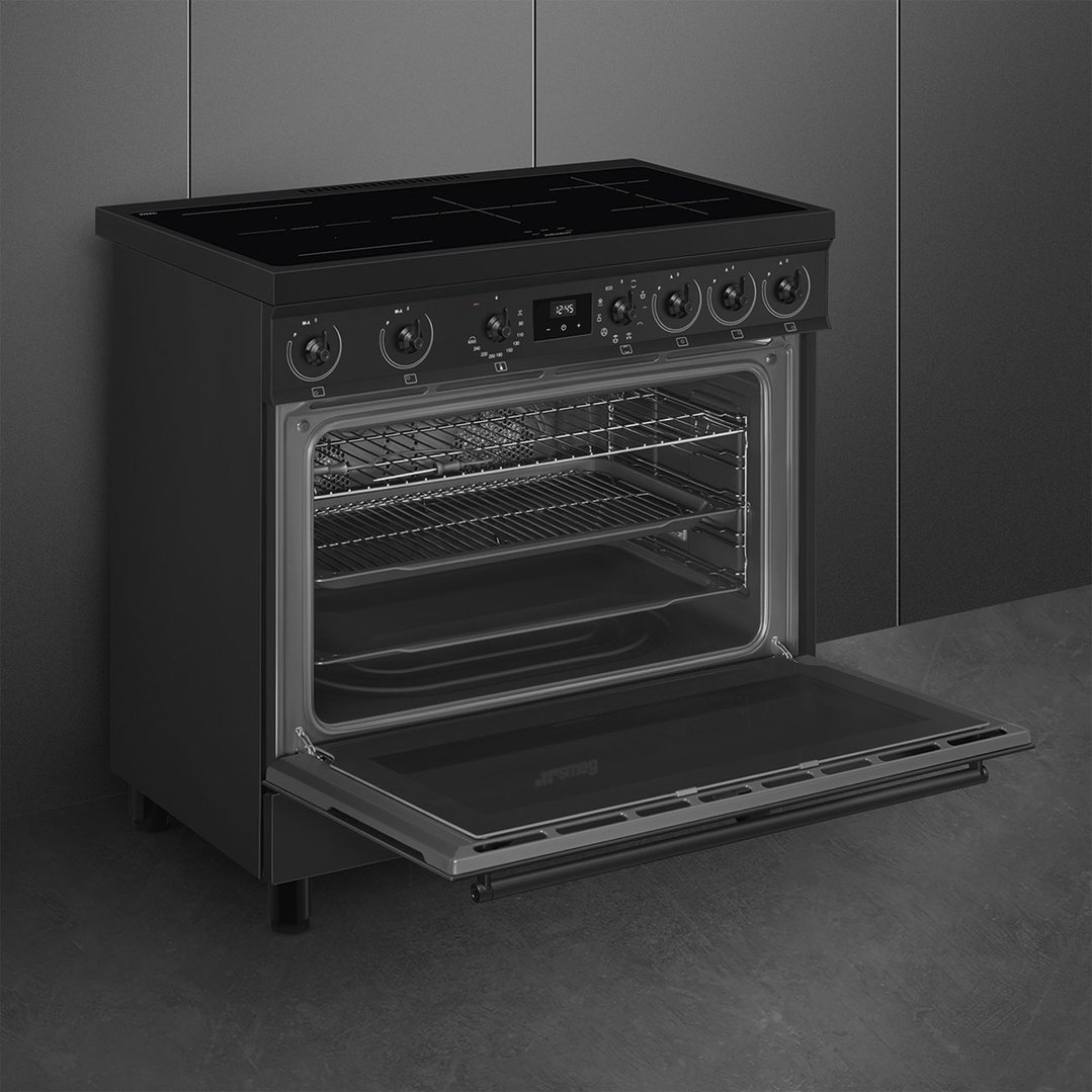Matte black freestanding oven with the door open, in a dark kitchen setting