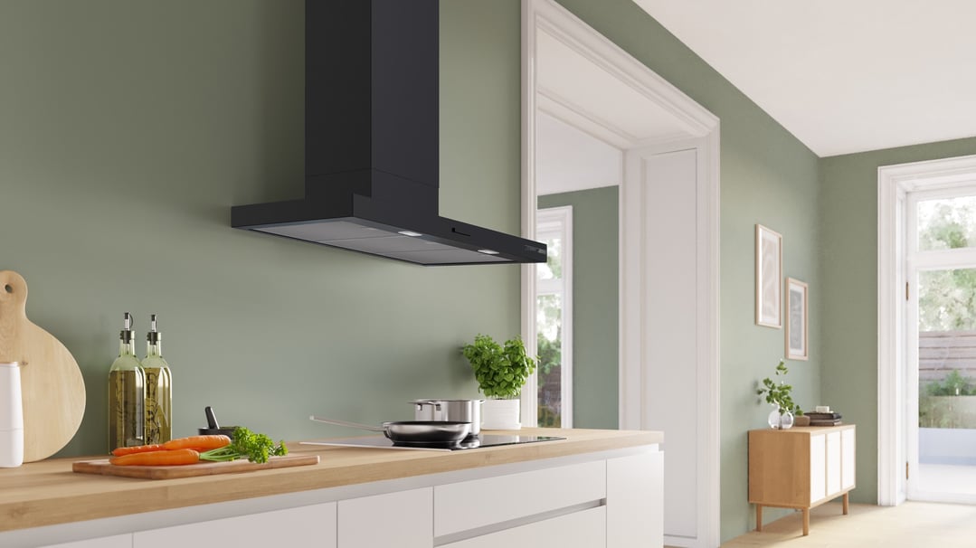 Black wall-mounted canopy rangehood above an induction cooktop in a modern kitchen