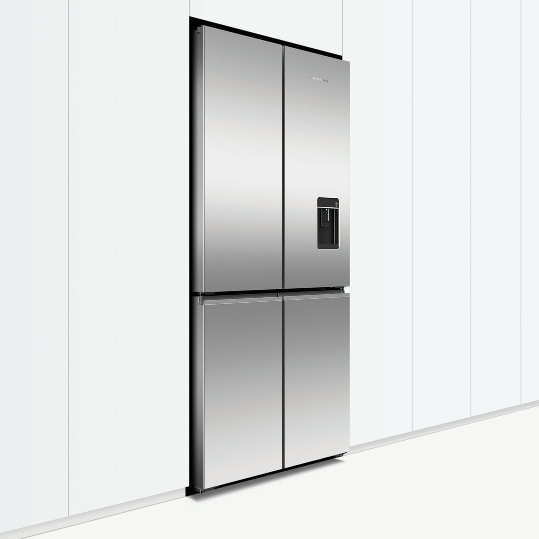 A stainless steel quad door refrigerator freezer with ice and water dispenser built into a kitchen wall