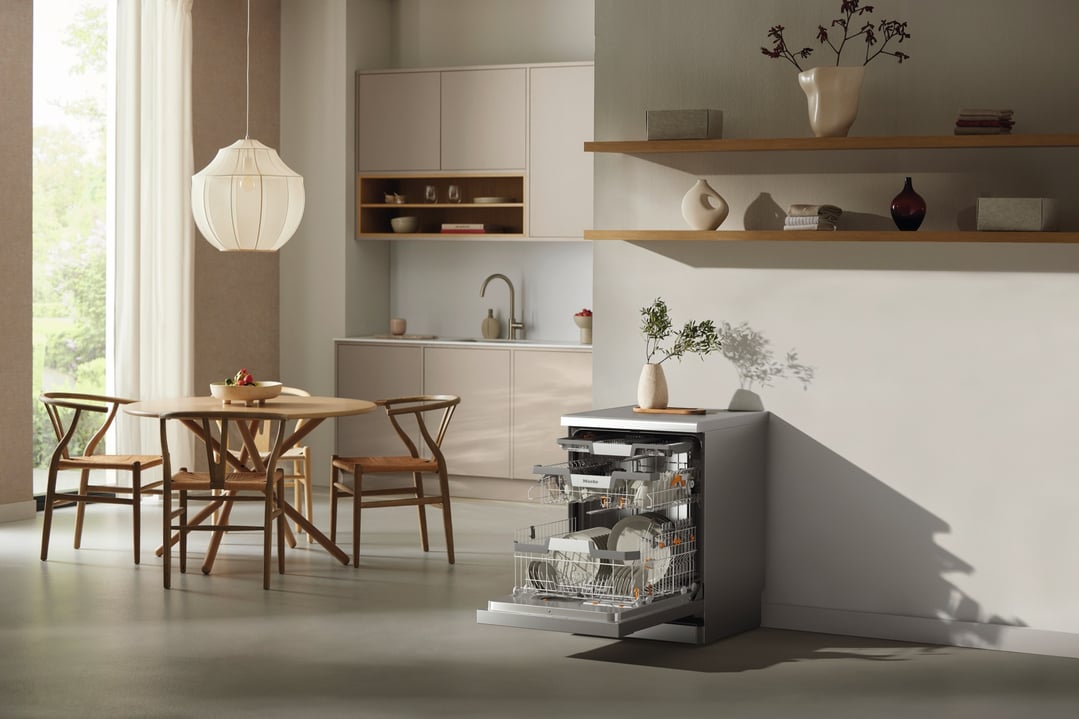 Freestanding dishwasher with open door in a modern kitchen and dining area