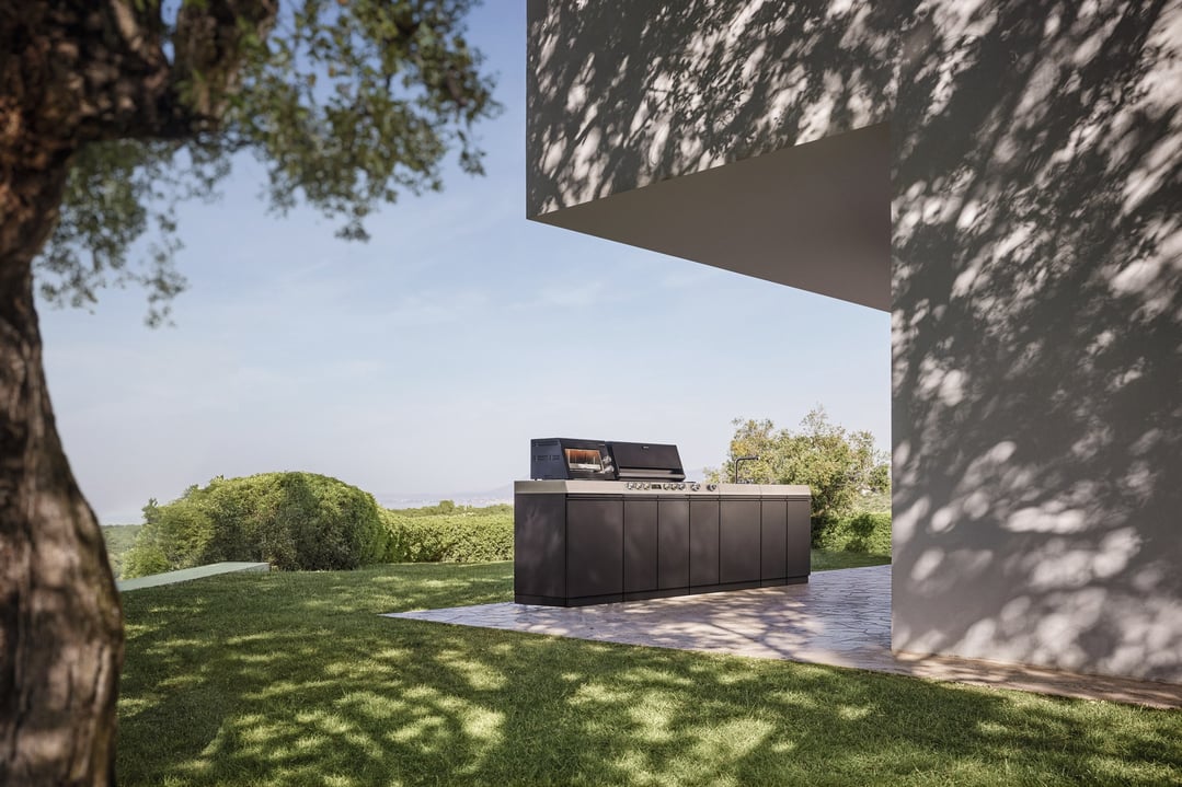 Black outdoor kitchen barbeque on a patio in a garden setting