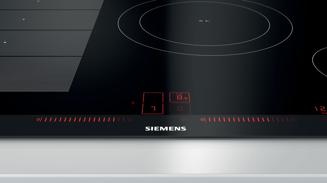 Close up of a Siemens cooktop with red digital controls illuminated