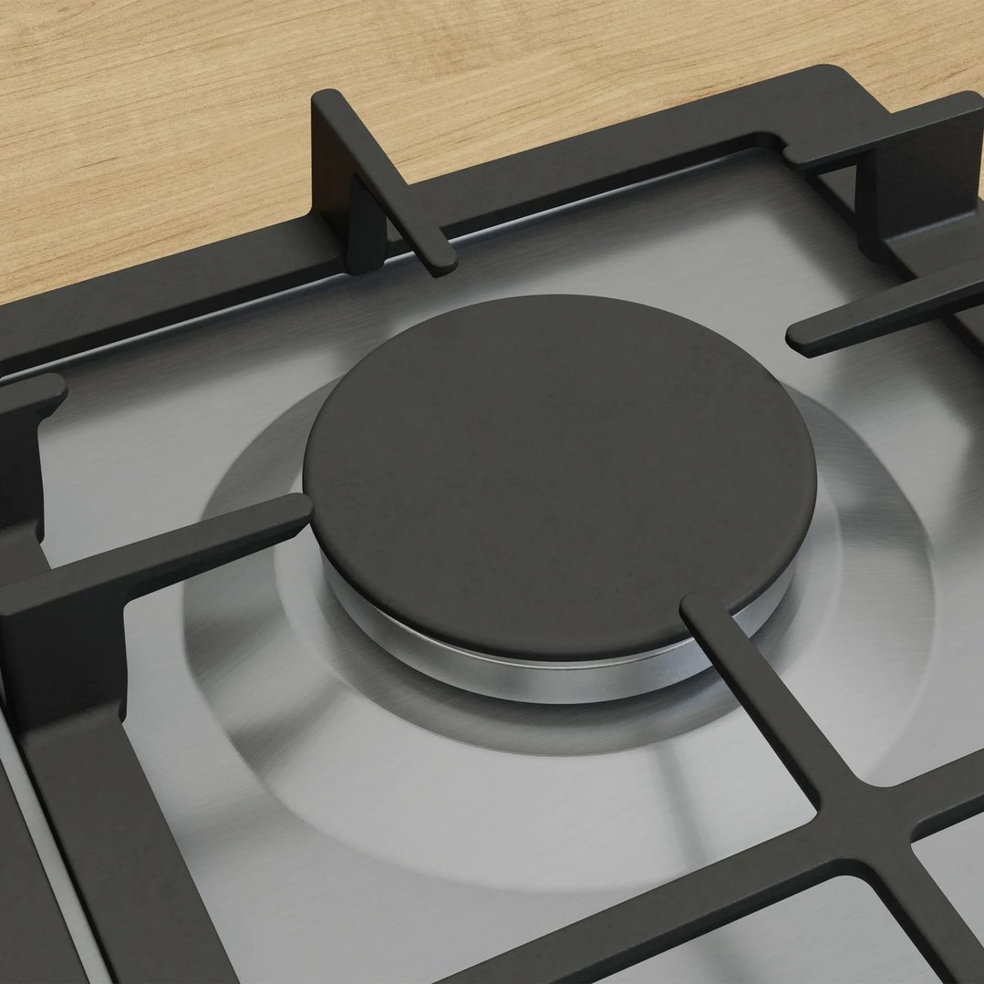 Close up of a gas cooktop burner and grates on a wooden countertop
