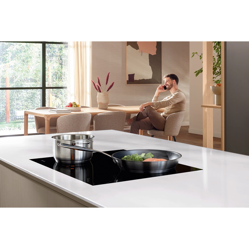 Induction cooktop with pots and pans on a kitchen island in a modern home