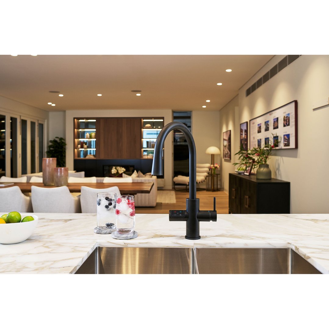 Black tap on a marble countertop with drinks in a modern kitchen