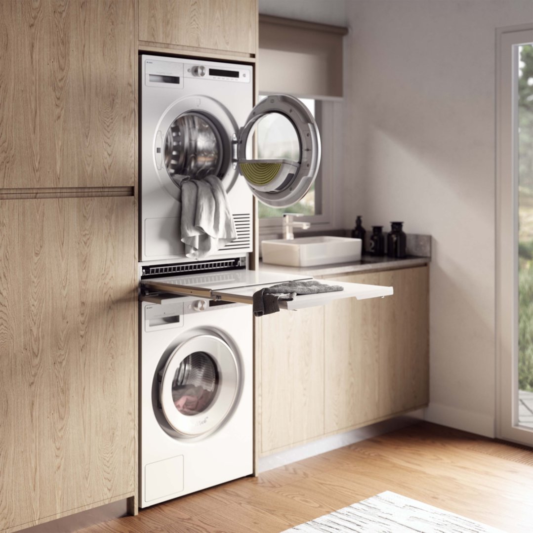 Pull-out shelf for laundry between a stacked washer and dryer in a laundry room