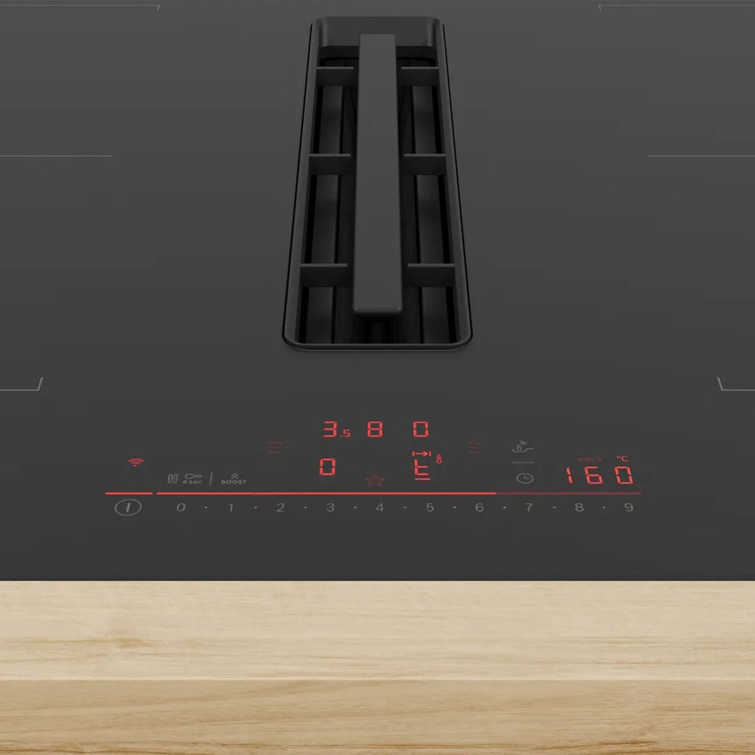 Close-up of a black cooktop with integrated ventilation and illuminated controls