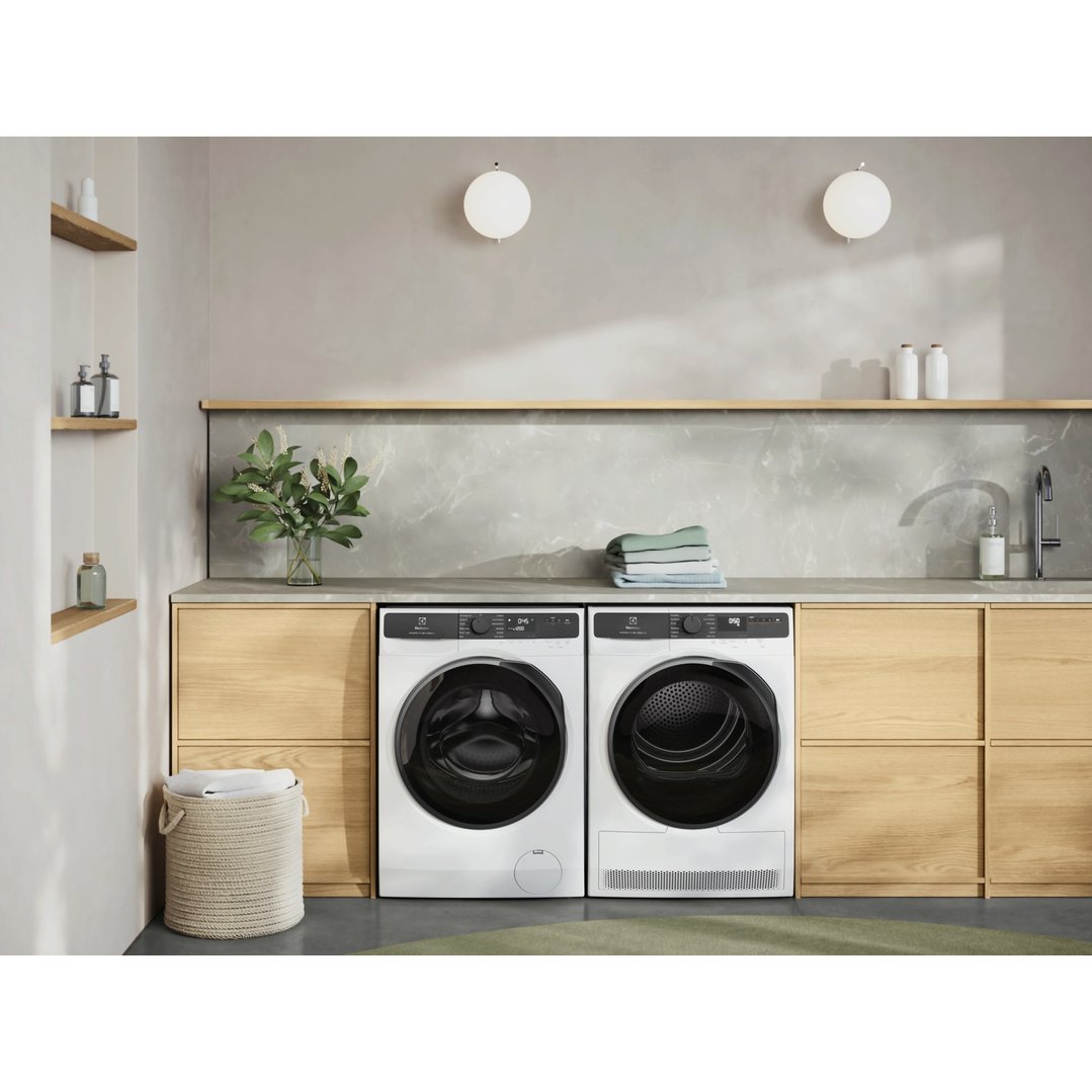 Washing machine and dryer in a modern laundry room with wooden cabinets