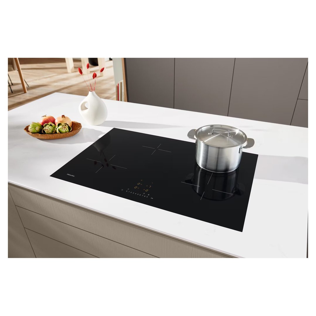 Miele induction cooktop with a pot on a white kitchen counter