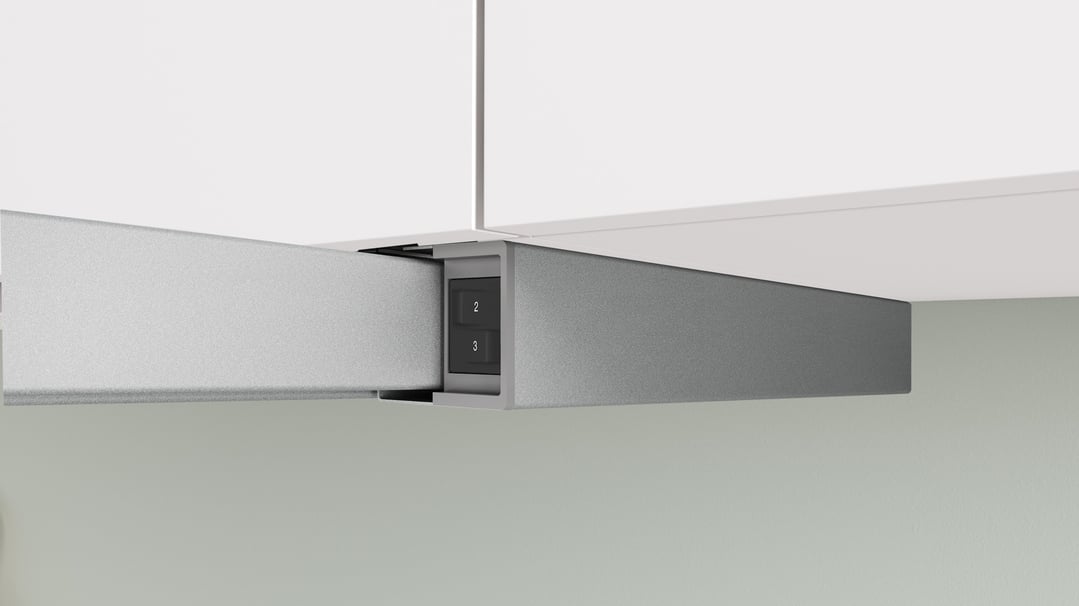 Silver metallic slideout rangehood partially extended under white cabinets