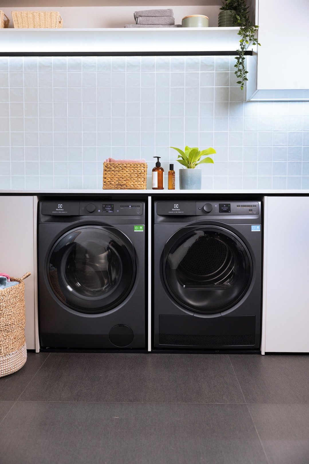 Two dark onyx laundry appliances in a styled laundry room with decor