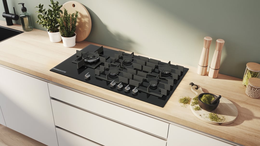 Black gas cooktop built into a light wood kitchen countertop