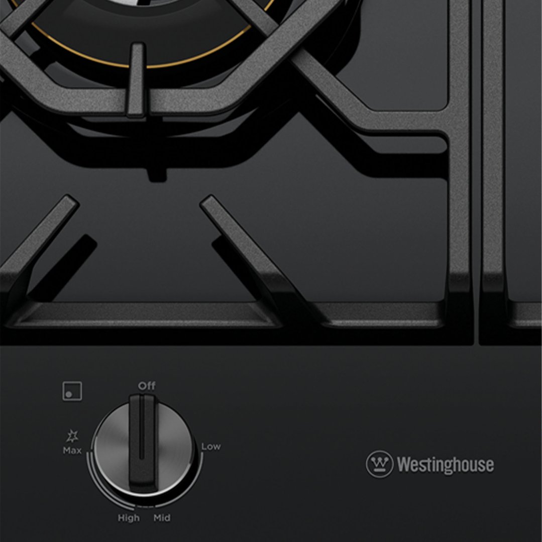 Close-up of a black gas cooktop with a control knob and Westinghouse logo