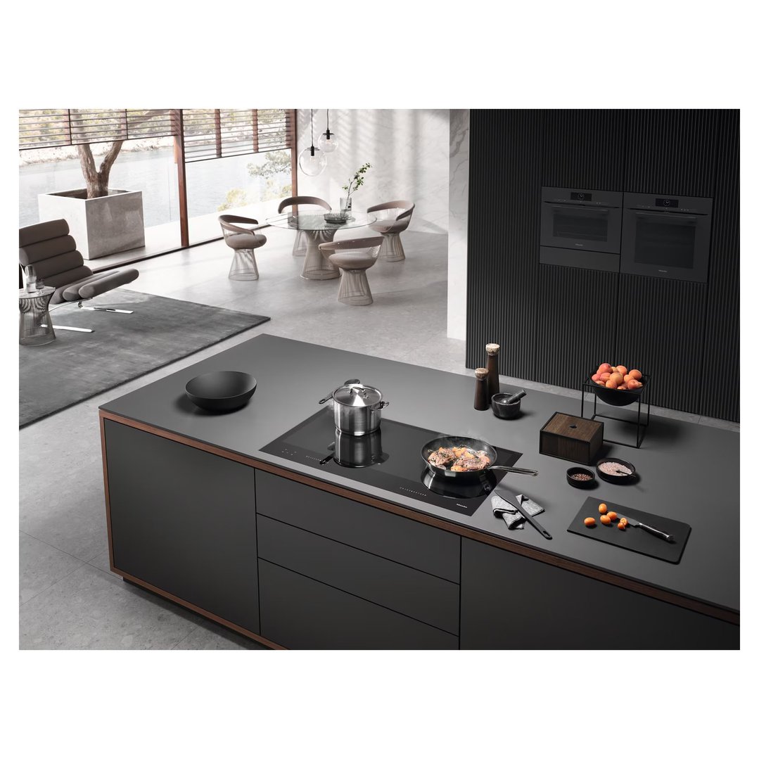 Induction cooktop with pots and pans on a kitchen island in a modern home