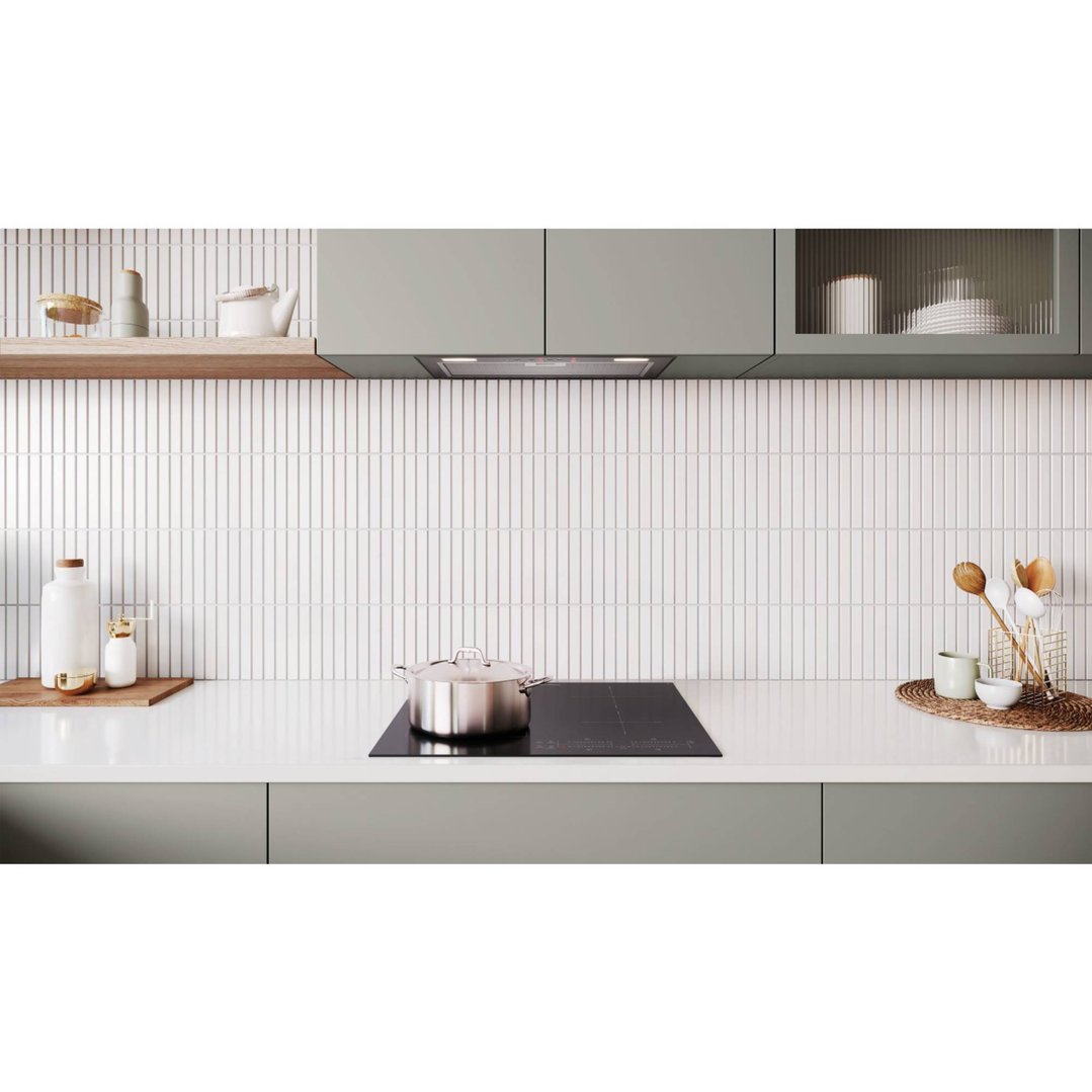 Induction cooktop with a pot on a white countertop in a modern kitchen