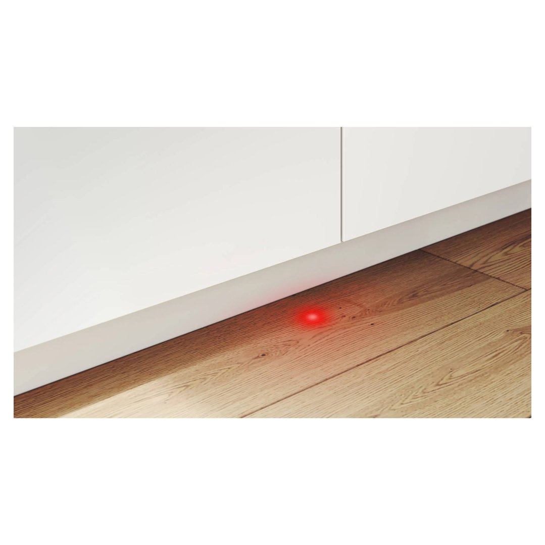 Red light projected onto wooden floor from integrated dishwasher