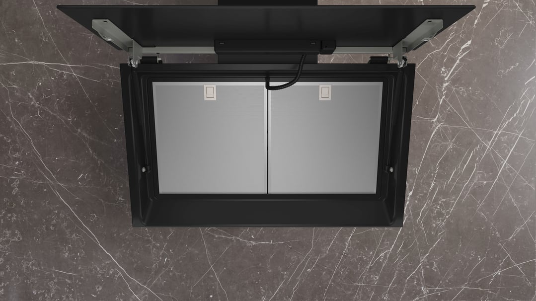 Overhead view of a black inclined rangehood mounted on a dark marble wall