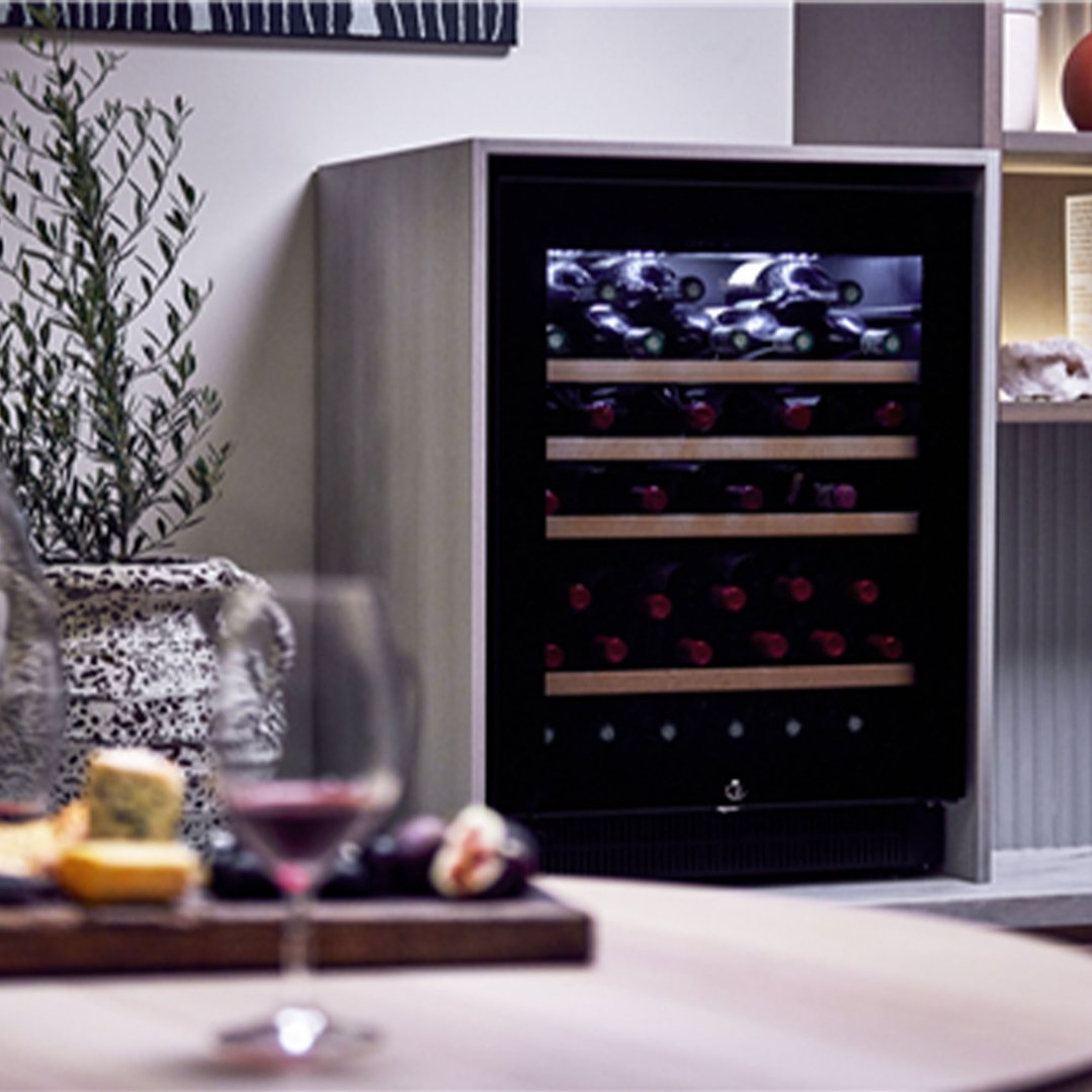 Wine cabinet in a styled setting with wine glasses and cheese