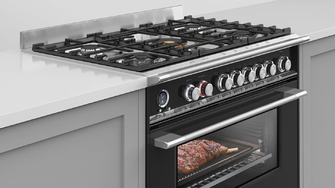 Black freestanding cooker with a roast cooking inside the oven